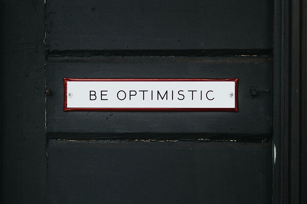 A sign that says be optimistic