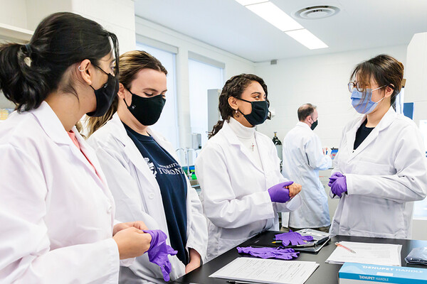 A group of female students talking in a lab