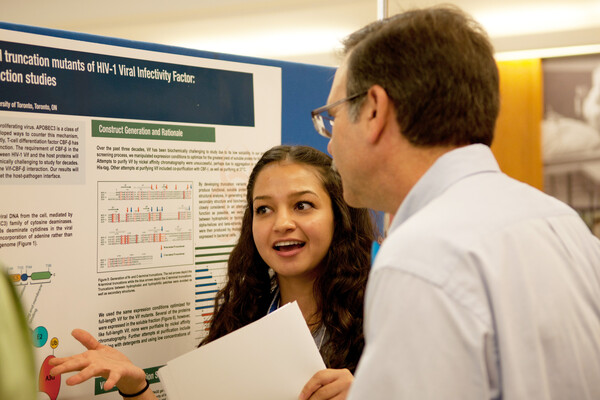 A student presenting a poster to a man