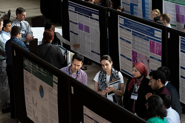 A group of people looking at research posters