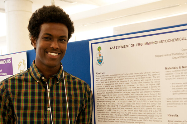 a student standing next to a research poster