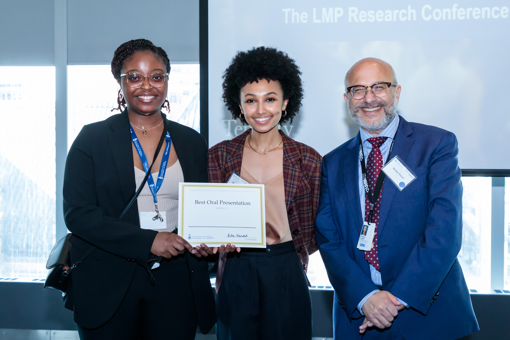 Gabrielle Retta and Gemma Kabeya winning an award at LMP's research conference 2022
