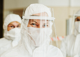 A woman in protective gear and a face shield